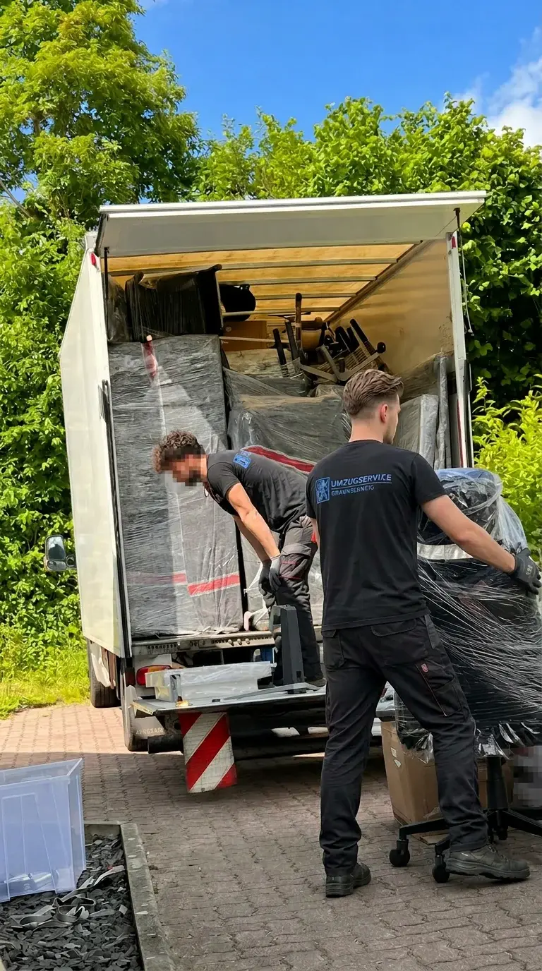 Möbelpacker verpacken Möbel mit Decken und Folie für den Transport